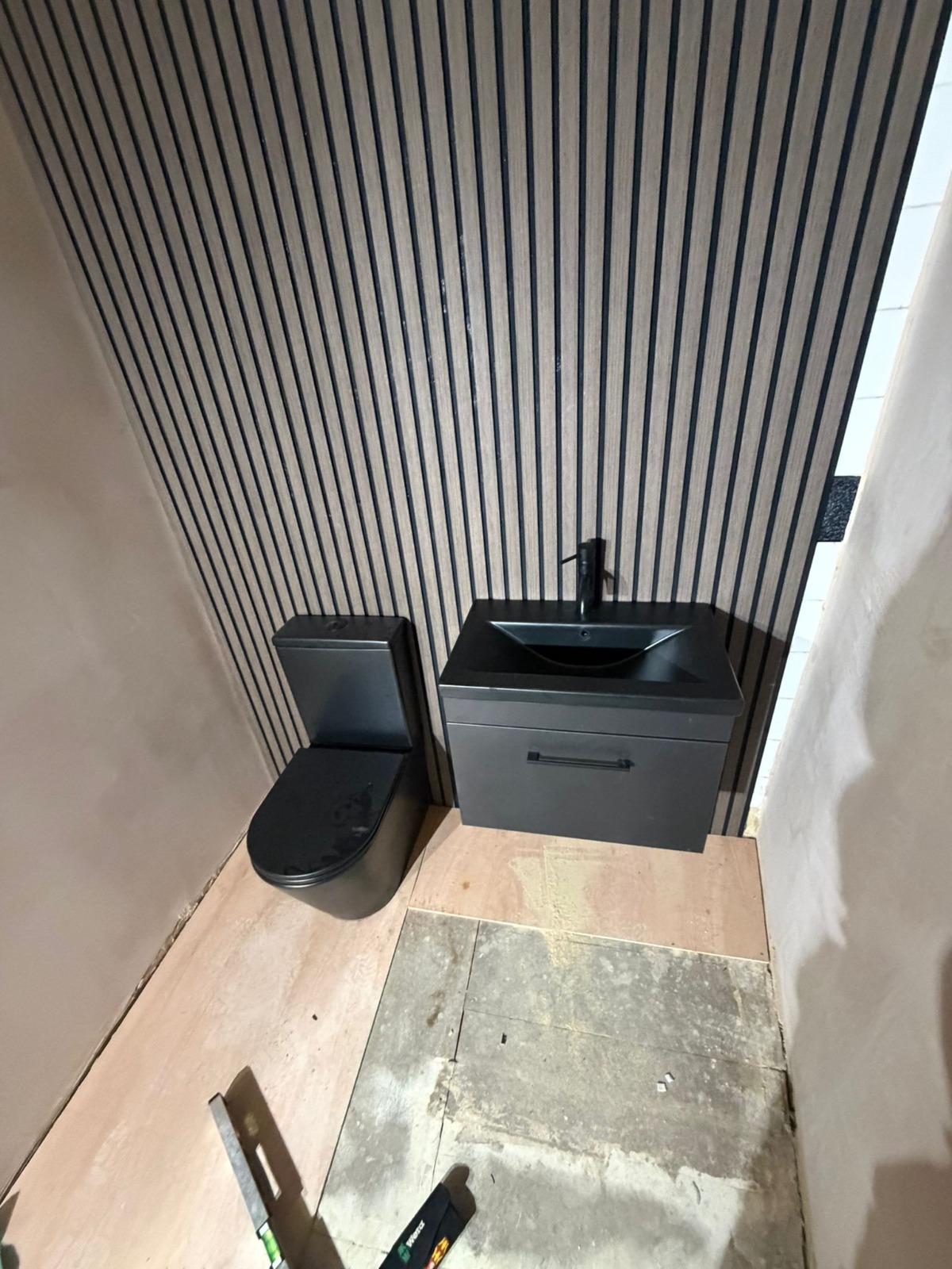 Modern matte black bathroom suite with slatted wall panelling fitted in Coventry