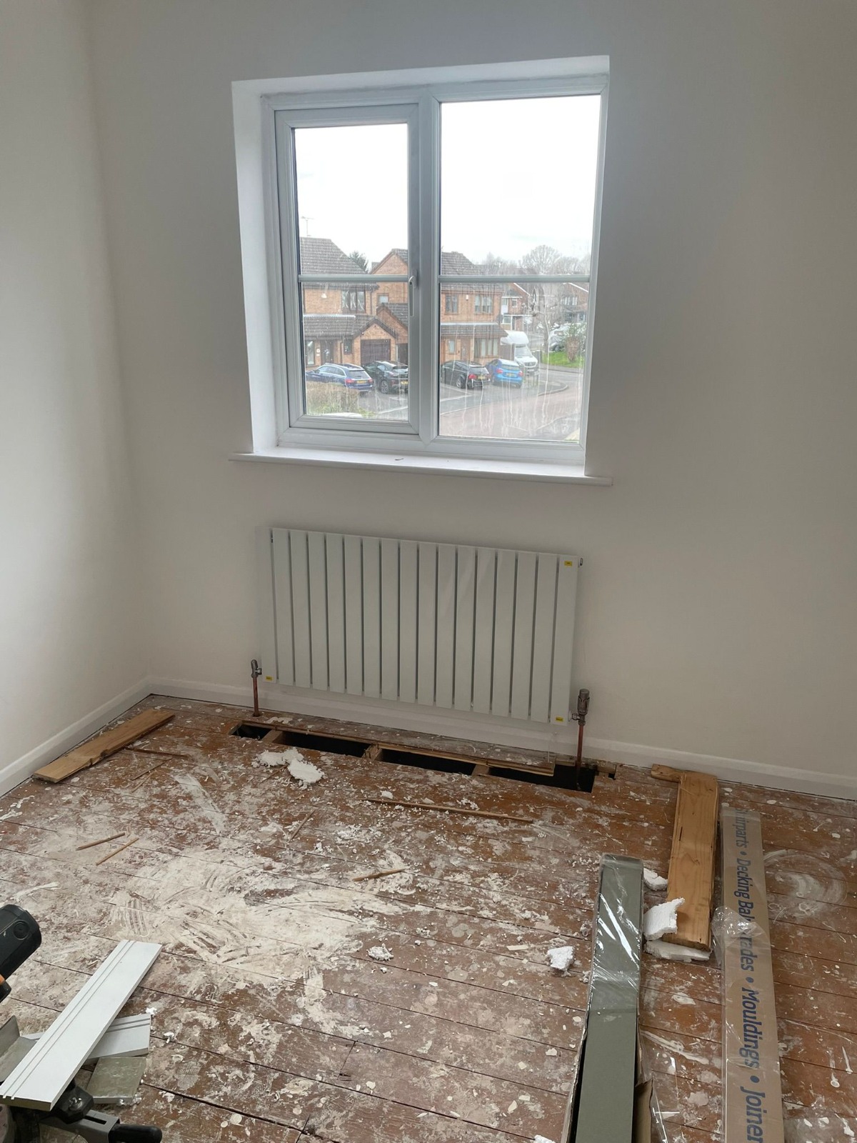 Central heating radiator fitted under window during property renovation