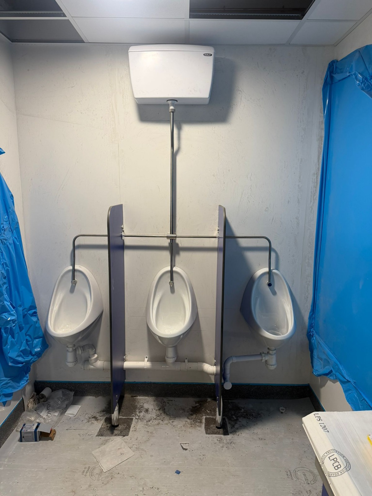 Commercial washroom urinal installation with concealed cistern