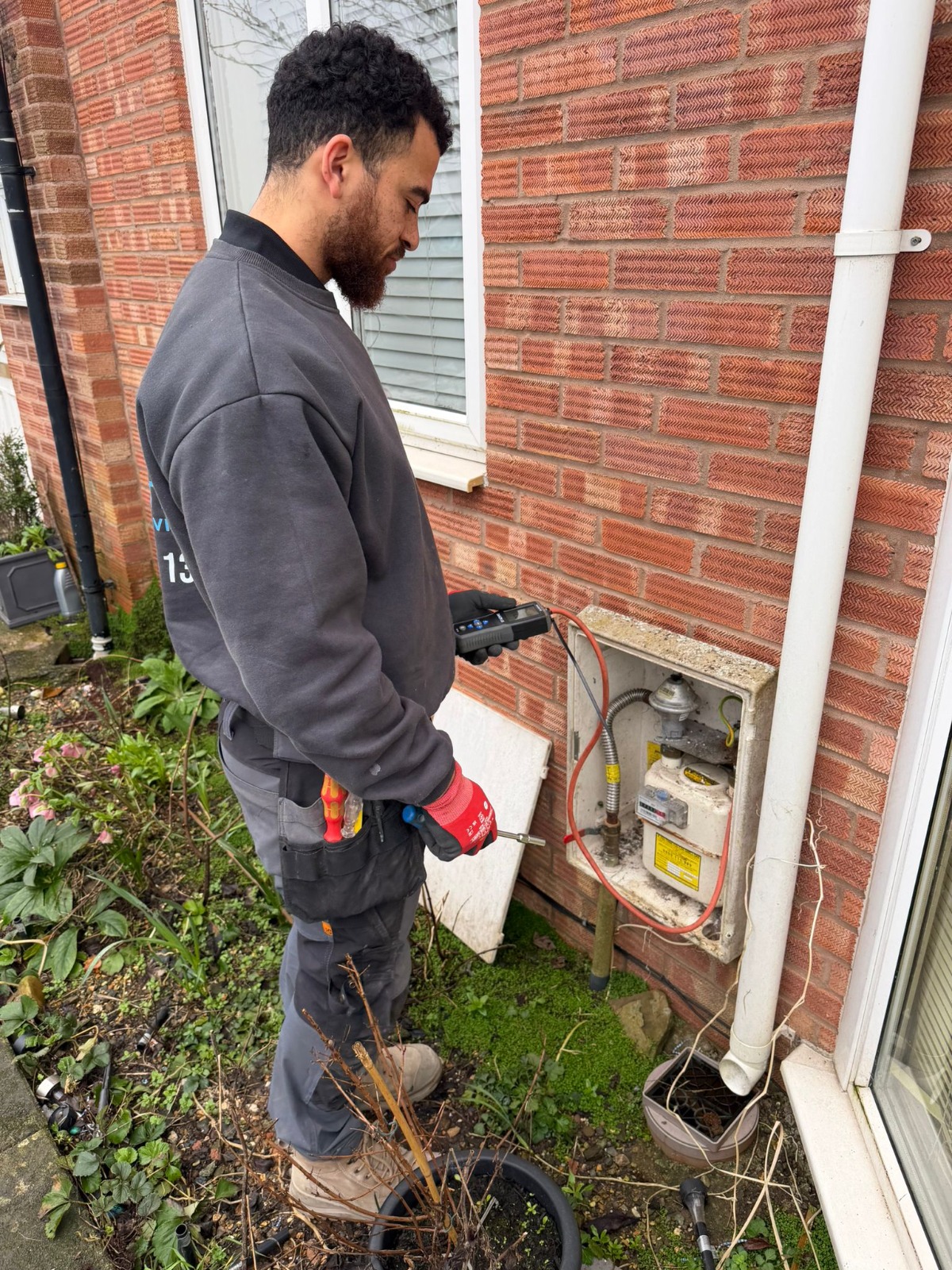 Gas Safe engineer carrying out a carbon monoxide and gas safety check on a meter